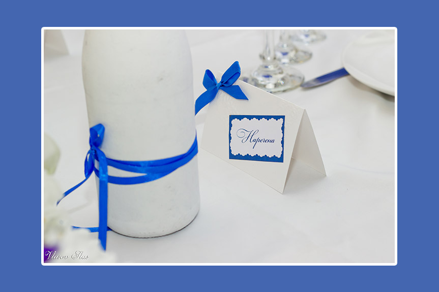 Blaue Schleifen auf weißem Brautpaartisch