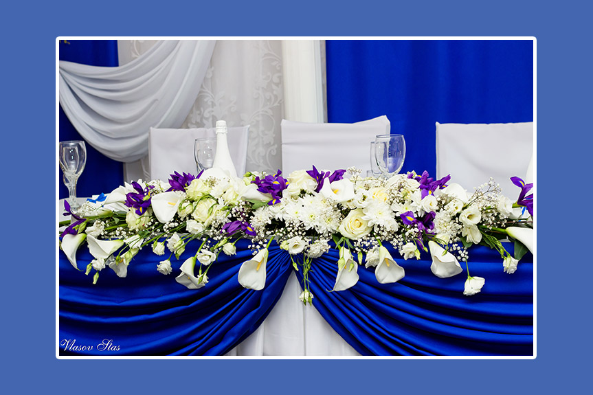 Hochzeitstafel mit blauem Satin und weißen Blumen