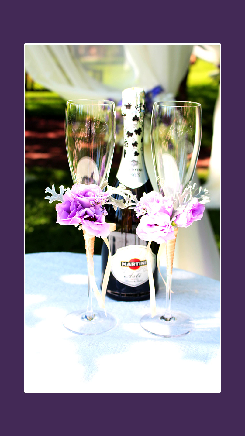 Violette Blumendeko auf Hochzeitsgläsern